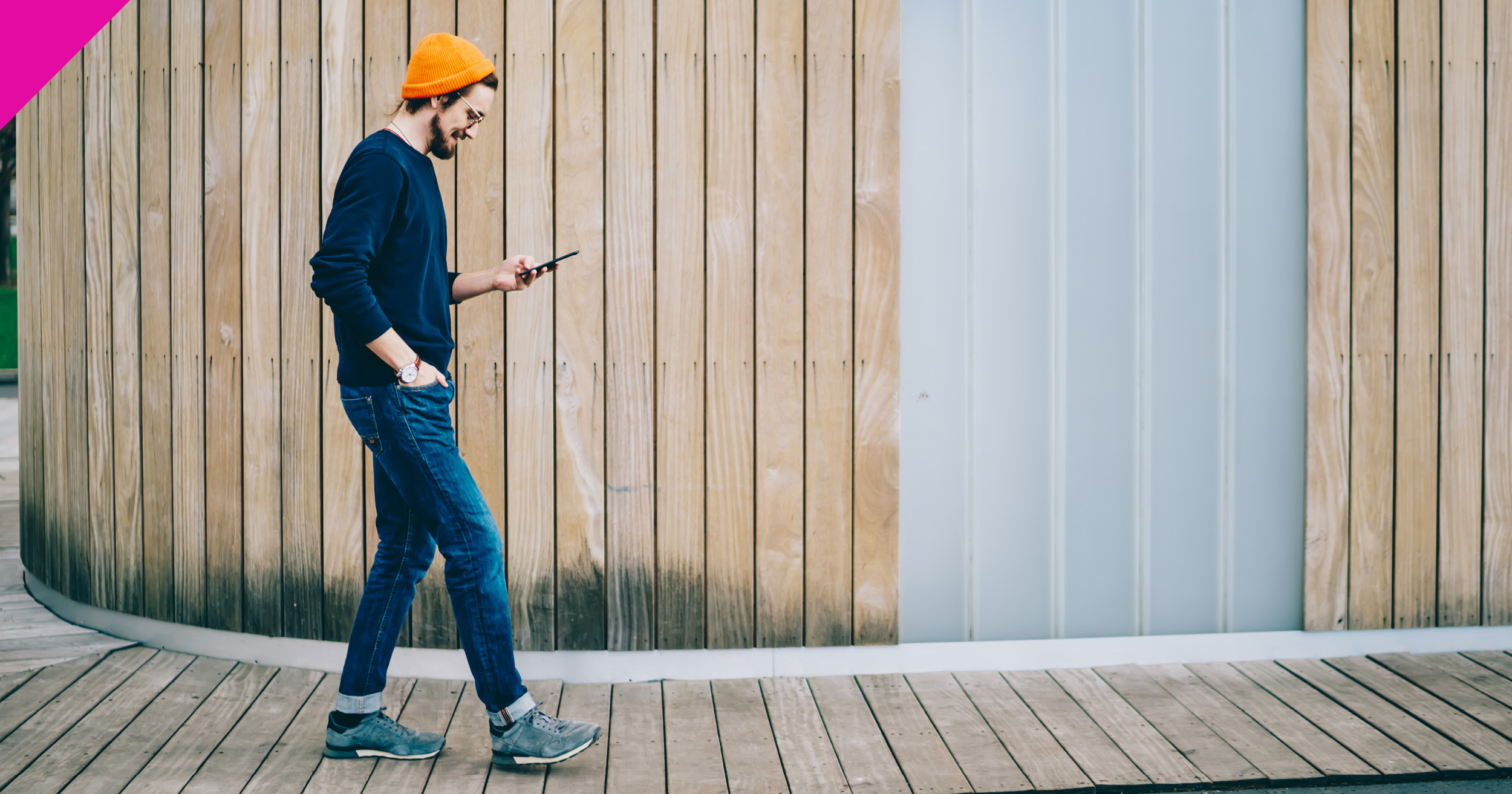 Man walking along looking at phone 