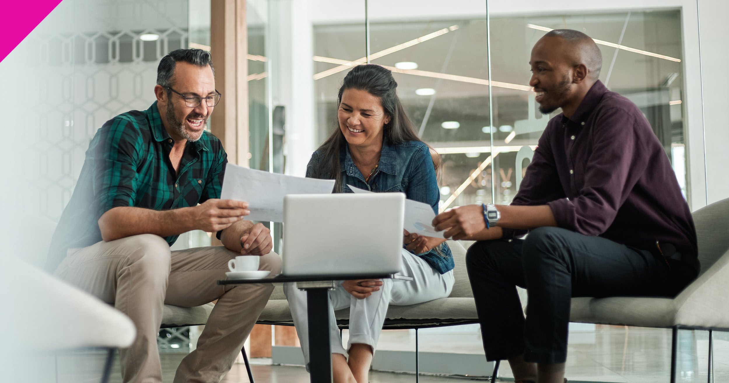 Three people sat looking at laptop