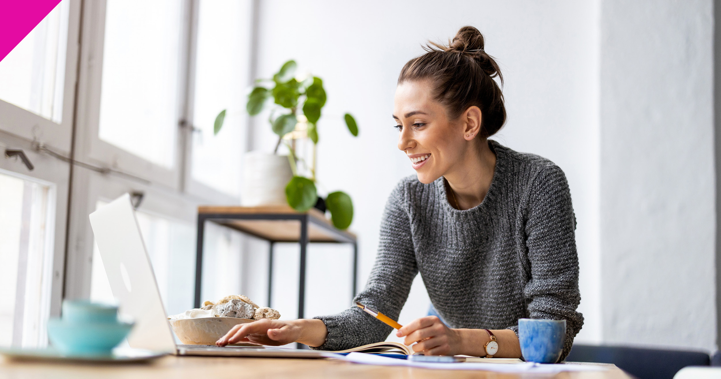 Woman stood at desk looking at laptop