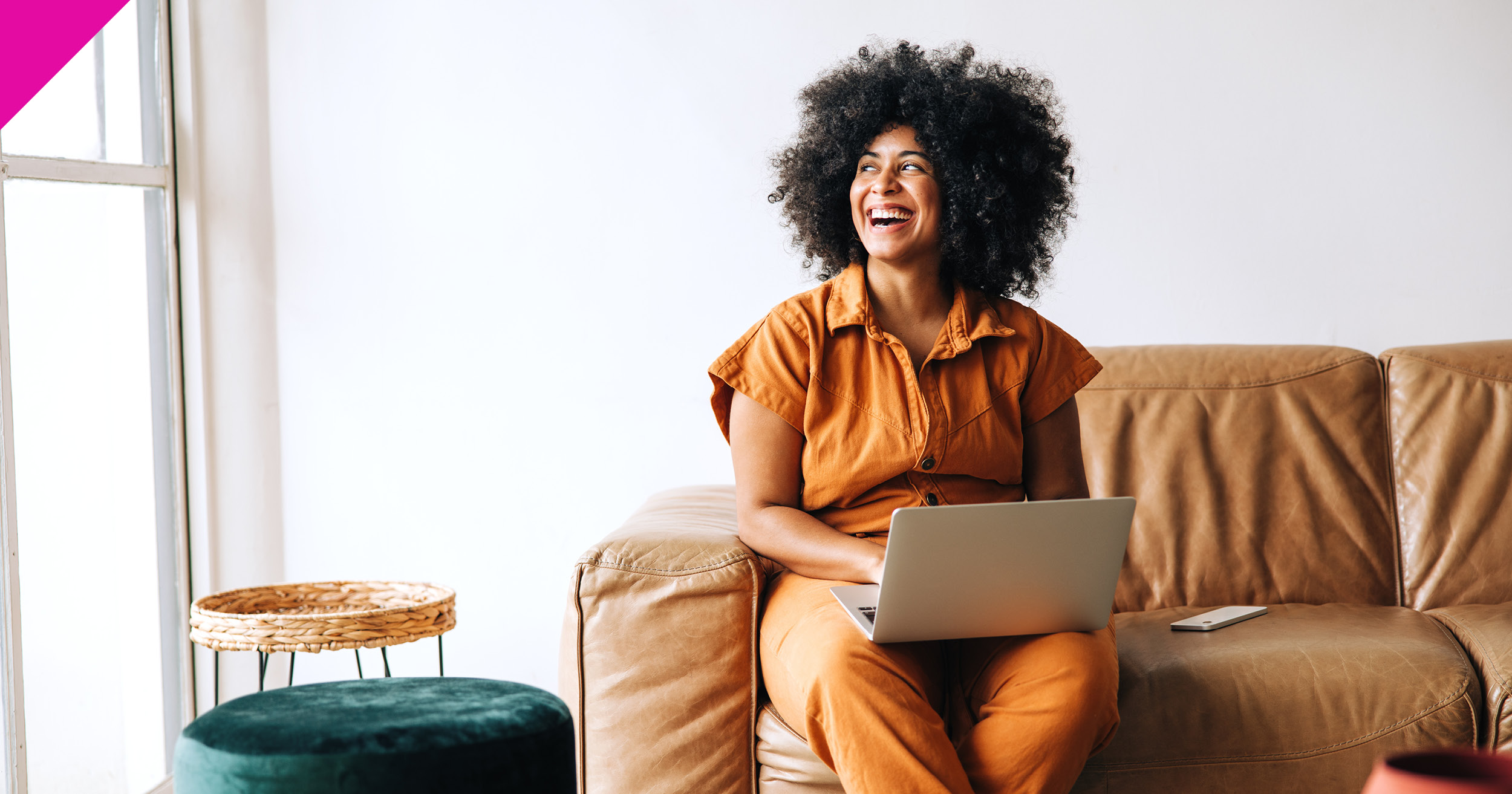 Woman sat on sofa using laptop